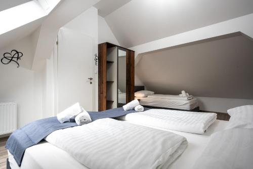 two beds in a room with white walls at Villa Krems Wachau Apartments an der historischen Stadtmauer in Krems an der Donau