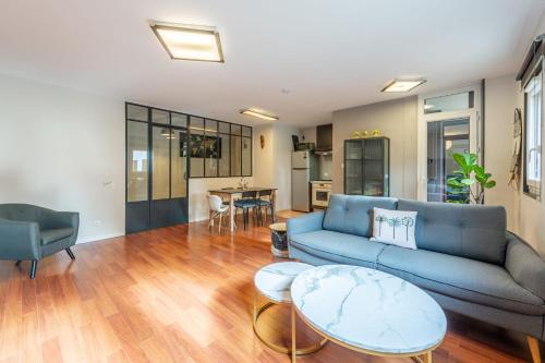 un salon avec un canapé bleu et une table dans l'établissement Les Feuillettes, à Annecy