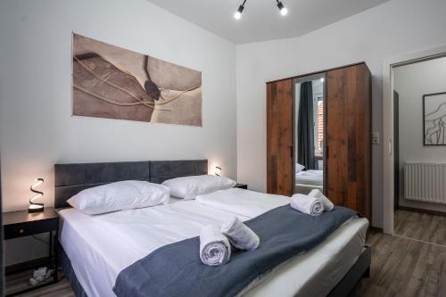 a bedroom with a large bed with towels on it at Villa Krems Wachau Apartments an der historischen Stadtmauer in Krems an der Donau