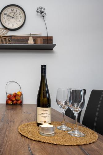 a bottle of wine and two glasses on a table at Villa Krems Wachau Apartments an der historischen Stadtmauer in Krems an der Donau
