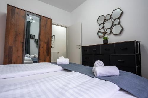 a bedroom with two beds and a large mirror at Villa Krems Wachau Apartments an der historischen Stadtmauer in Krems an der Donau
