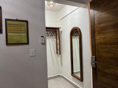 a bathroom with a wooden door and a mirror at Ixic posada boutique in Zihuatanejo