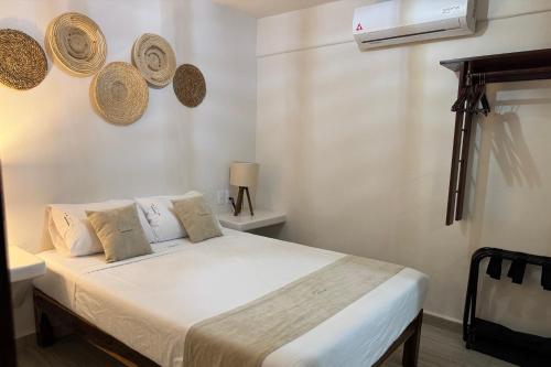 a bedroom with a bed with hats on the wall at Ixic posada boutique in Zihuatanejo