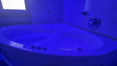 a blue bath tub in a bathroom with a window at Spazio Prestige in Milan