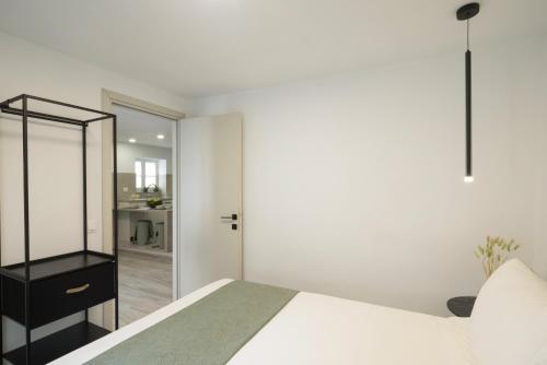 a bedroom with a white bed and a mirror at Victoria's Gem - Apartment in the Heart of Corfu Old Town in Corfu