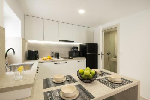 a kitchen with a bowl of fruit on a counter at Victoria's Gem - Apartment in the Heart of Corfu Old Town in Corfu