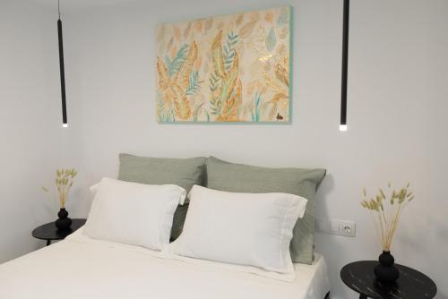 a bed with white pillows and a painting above it at Victoria's Gem - Apartment in the Heart of Corfu Old Town in Corfu