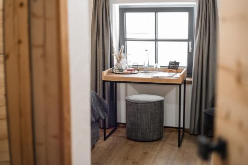 a desk in a room with a window at Unternberg Hof Ruhpolding in Ruhpolding