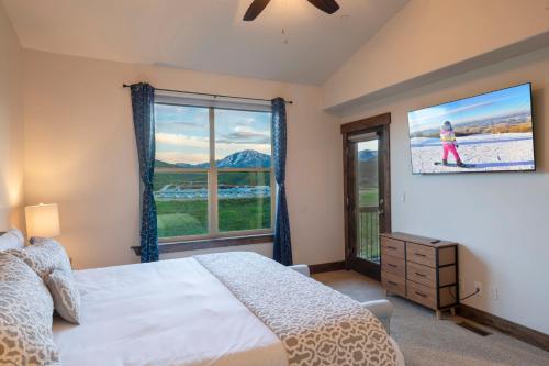 a bedroom with a bed and a large window at Minutes to Deer Valley and Park City, Private Hot Tub, Mountain Views, Living + Family, More in Heber City