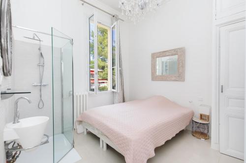 une salle de bain blanche avec un lit et un lavabo dans l'établissement Palais Beaulieu Magnifique 3p 2 chambres, à Cannes