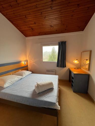 une chambre avec un lit et une fenêtre dans l'établissement Appartement à 200 m du lac de la Raviège, à La Salvetat-sur-Agout