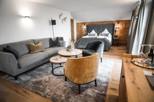 a living room with a couch and a bed at Unternberg Hof Ruhpolding in Ruhpolding