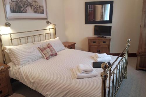 a bedroom with a large bed with towels on it at The Snug a cosy, quirky detached cottage with sea views in Innellan