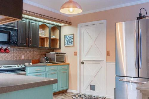 a kitchen with blue cabinets and a refrigerator at Elegant Palm Bay Getaway with Large Backyard in Palm Bay