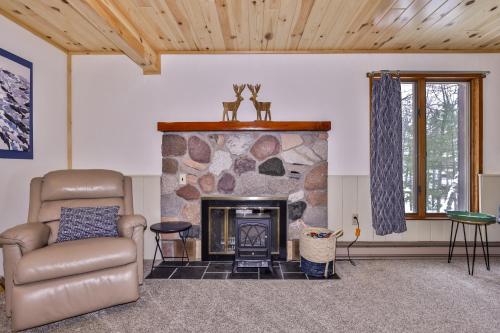 a living room with a stone fireplace and a couch at Boulder Lakehouse in Boulder Junction