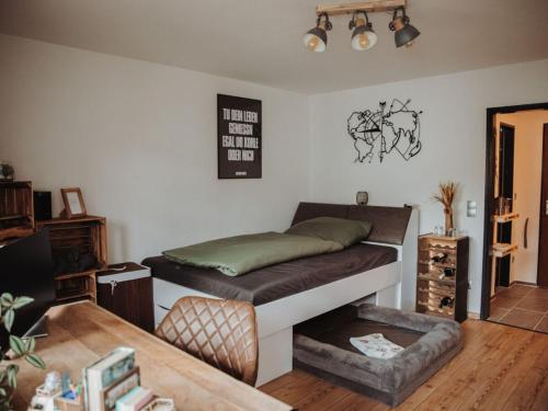 a bedroom with a bed and a chair in it at Pura Vida - holiday apartment in Fischen