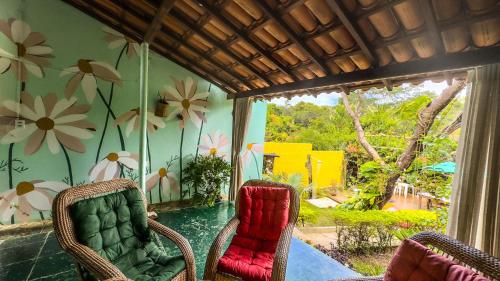 a room with two chairs and a swimming pool at Pousada Canto Feliz in Serra do Cipo