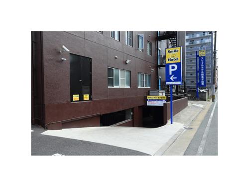 a parking sign on a sidewalk next to a building at Smile Hotel Kumamoto Suizenji - Vacation STAY 59289v in Kumamoto