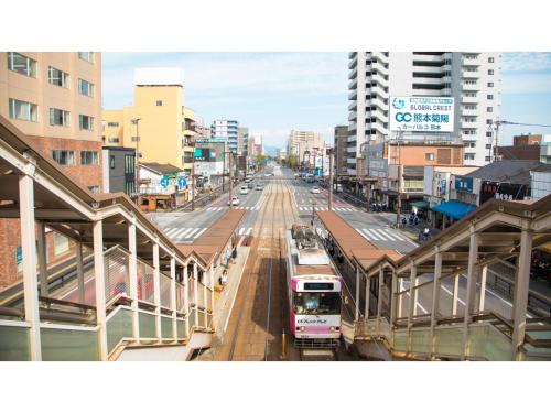 a train station with a bus on a city street at Smile Hotel Kumamoto Suizenji - Vacation STAY 59289v in Kumamoto