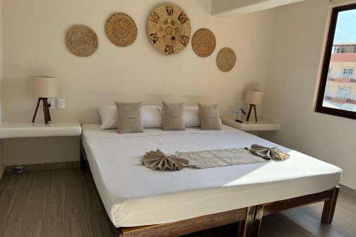 a bedroom with a large white bed with white sheets at Ixic posada boutique in Zihuatanejo