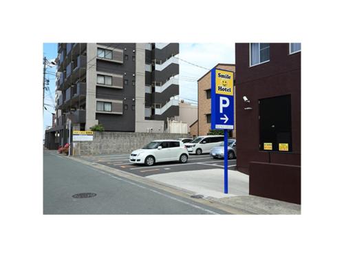 a parking lot with cars parked next to a parking sign at Smile Hotel Kumamoto Suizenji - Vacation STAY 59267v in Kumamoto