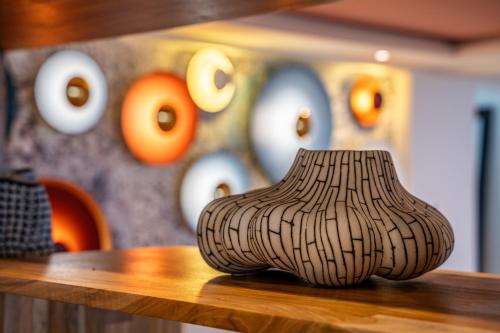 a vase sitting on top of a wooden table at Lia Hotel Jaco in Jacó