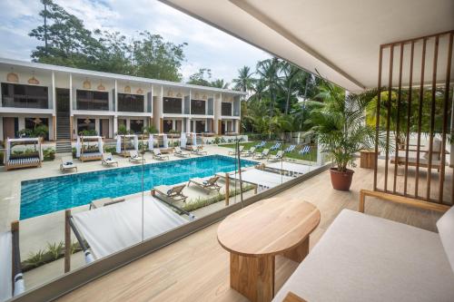 an indoor pool with lounge chairs and a table at Lia Hotel Jaco in Jacó