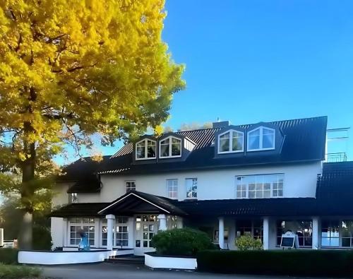 a large white building with a black roof at Park Hotel Berlin in Bad Fallingbostel