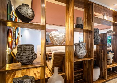 a room with wooden shelves filled with vases at Lia Hotel Jaco in Jacó