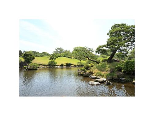 a pond in a park with rocks in the water at Smile Hotel Kumamoto Suizenji - Vacation STAY 59277v in Kumamoto