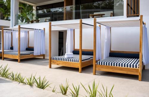 a group of four porch swings on a beach at Lia Hotel Jaco in Jacó