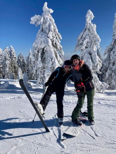 two people are posing for a picture in the snow at Blatenský House 393 - Apartmá 3 in Abertamy