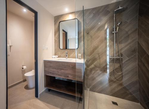 a bathroom with a sink and a shower at Lia Hotel Jaco in Jacó