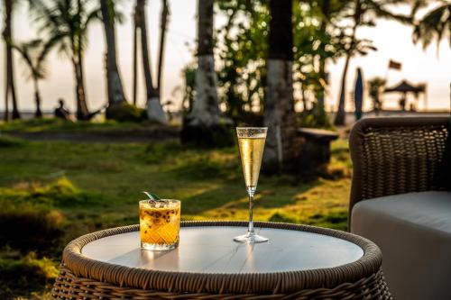 a table with a glass of champagne and a drink at Lia Hotel Jaco in Jacó