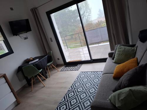 un salon avec un canapé et une grande fenêtre dans l'établissement LE REFUGE DES CASCADES, à Vernet-les-Bains