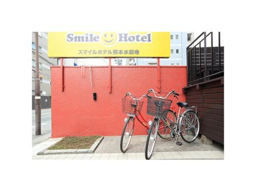 two bikes parked next to a red wall at Smile Hotel Kumamoto Suizenji - Vacation STAY 59271v in Kumamoto