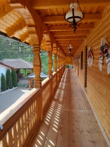 an empty porch of a wooden house with a wooden ceiling at Pensiunea Malinul in Bîrsana