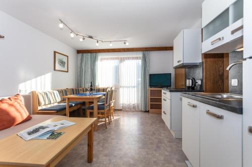 a kitchen and living room with a table and a dining room at Bergbauernhof Kinderparadies Oberhasenberghof in Taxenbach