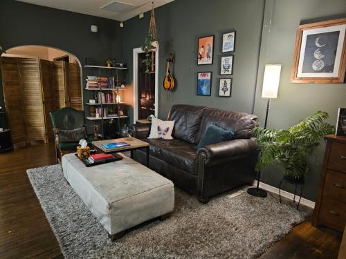 a living room with a leather couch and a coffee table at Tranquility at the House of Alchemy Hollywood in Los Angeles