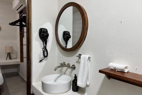 a bathroom with a sink and a mirror at Ixic posada boutique in Zihuatanejo