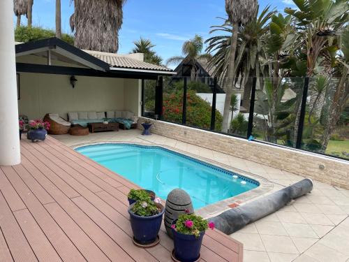 a swimming pool on a wooden deck with plants at The Beach Residence in Swakopmund