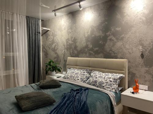 a bedroom with a bed and a wall at СВІТЛО ЦІЛОДОБОВО Rent-Kiev metro Chernigivska ViP in Kyiv