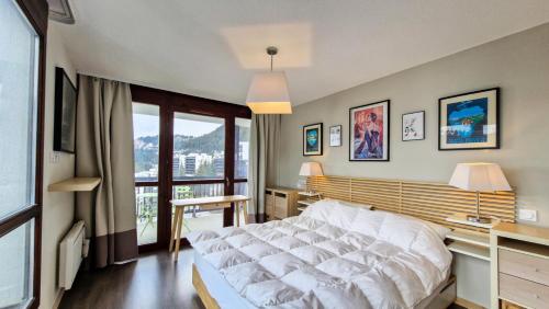 une chambre avec un grand lit et une grande fenêtre dans l'établissement Résidence Le Panoramic - Appartement spacieux · Départ et retour skis aux pieds · Piscine · Parking inclus · Spa MAE-6931, à Magland