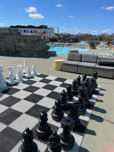 a chess board on a patio next to a pool at Days Inn by Wyndham Virginia Beach At The Beach in Virginia Beach