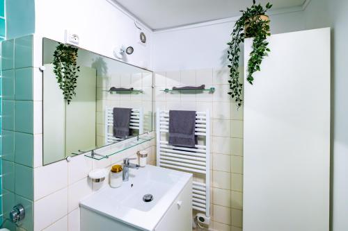 une salle de bain avec un lavabo et un miroir dans l'établissement Appartement Typique au Coeur du Marais, à Paris