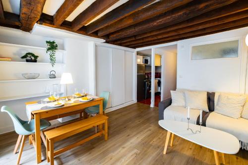 un salon avec une table et un canapé dans l'établissement Appartement Typique au Coeur du Marais, à Paris