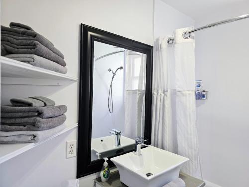 a bathroom with a sink and a mirror and towels at Espace William by Hébergements DCL in Quebec City