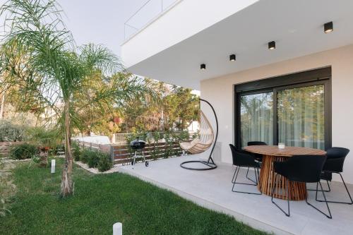 a patio with a table and chairs and a garden at Kyan Executive Suites in Iraklitsa