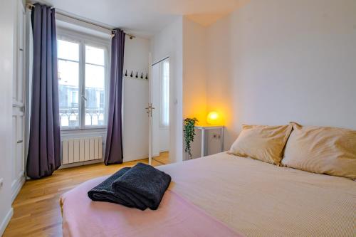 - une chambre avec un grand lit et des rideaux violets dans l'établissement Cosy Apt 6 Guests for Family, à Paris