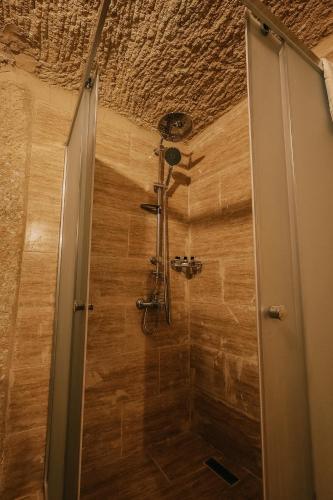 a shower in a room with a wooden ceiling at akile ablanın evi in Urgup